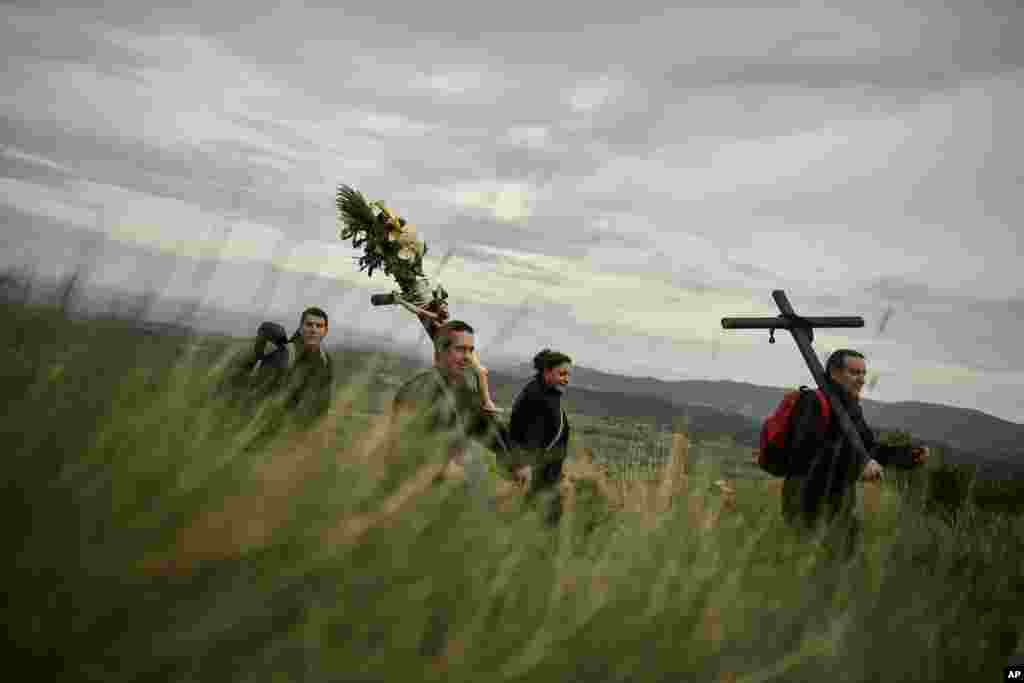 Catholic penitents of the Ujue Virgin carrying a crucifix decorated with flowers take part in a pilgrimage from Tafalla and other villages to the small town of Ujue, northern Spain.