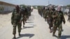 Members of Somalia's al- Shabab militant group patrol on foot on the outskirts of Mogadishu, March, 5, 2012.