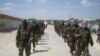 Members of Somalia's al- Shabab militant group patrol on foot on the outskirts of Mogadishu, March, 5, 2012.