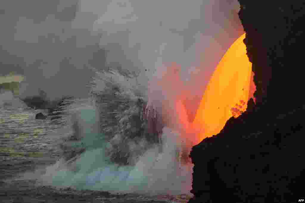 This image obtained from the U.S. Geological Survey's Hawaiian Volcano Observatory showing a lava stream, pouring out of the lava tube on the sea cliff at the Kamokuna ocean entry from the Kilauea Volcano, Hawaii, Jan. 29, 2017.