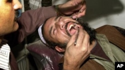 Doctor Abdul Salam, a dentist, checks a cavity of villager Gul Mohammad at his clinic in Kabul, Afghanistan, Saturday Dec.14, 2002. People living in villages often come to the city for medical check ups, as there are no doctors in the villages. (AP Photo/