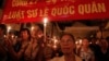 FILE - Protesters hold candles during a mass prayer for political dissident Le Quoc Quan at Thai Ha church in Hanoi June 30, 2013. 