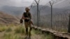 FILE - In this Aug. 3, 2021 file photo, Pakistan Army troops patrol along the fence on the Pakistan Afghanistan border at Big Ben hilltop post in Khyber district, Pakistan.