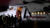 A handcuffed migrant boards a plane for a deportation flight to Ecuador, in the framework of the memorandum of cooperation signed between Panama and the U.S., at the Albrook "Marcos A. Gelabert" International Airport in Panama City, Sept. 20, 2024.