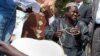 A man smiles as he receives his sheep for Tabaski