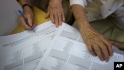 2016年9月11日克罗地亚选民在投票站检查他们的选票。