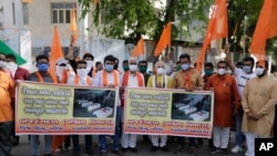 Supporters of Vishwa Hindu Parishad, or World Hindu Council, hold posters showing coffins of Indian army soldiers killed in clashes with China, during a protest in Ahmedabad, India, June 20, 2020. 
