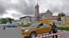 A police officer stands guard outside the Holy Trinity Catholic Church in Nigeria's capital Abuja, June 24, 2012, after tit-for-tat attacks between Muslims and Christians in Kaduna, sparked by suicide bombings blamed on Islamist sect Boko Haram.