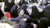  Iranians mourn over the covered bodies of loved ones in the village Baje-Baj, near the town of Varzaqan, who were killed in twin earthquakes that hit northwestern Iran, August 12, 2012.