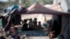 FILE - Displaced children pose for a photo as they sit in their family's tent at a camp for internally displaced people in the outskirts of Sana'a, Yemen, June 8, 2016.
