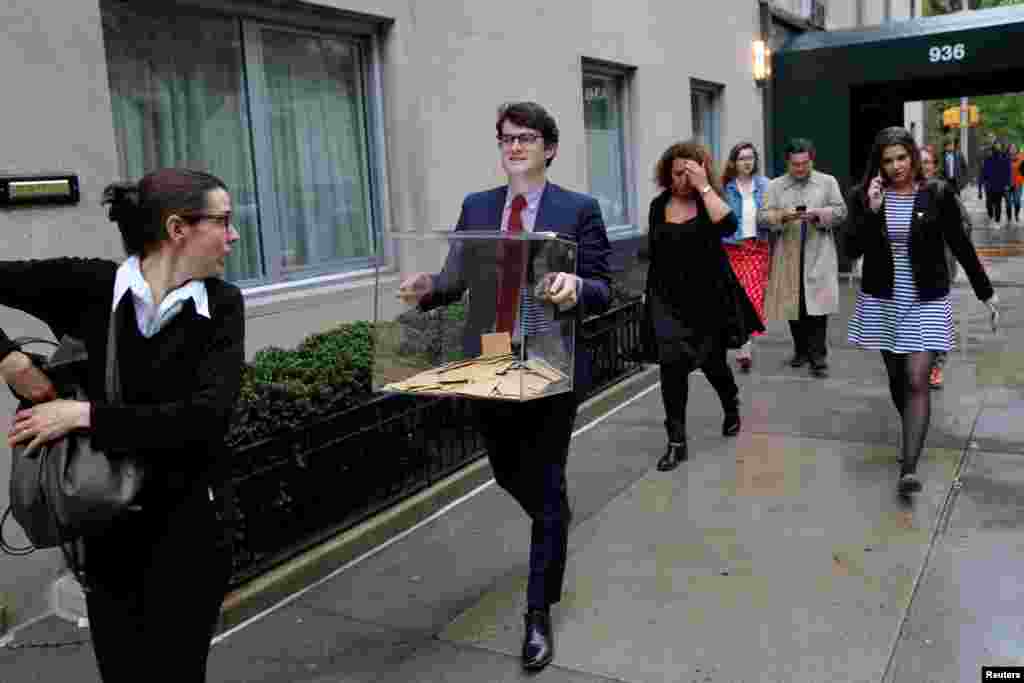 A volunteer carrying completed voting ballots evacuates the Consulate General of France after a New York Police identified a suspicious vehicle parked outside the entrance in Manhattan, New York.