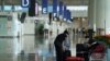 FILE - A woman, wearing a face mask following the coronavirus disease (COVID-19) outbreak, sorts luggage at Hong Kong International Airport in Hong Kong, Oct. 20, 2020. 