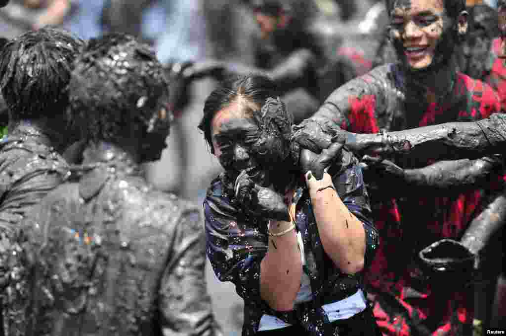 People smear plant ash onto each other during "Monihei Carnival", in Cangyuan, Yunnan province, China, April 30, 2017.
