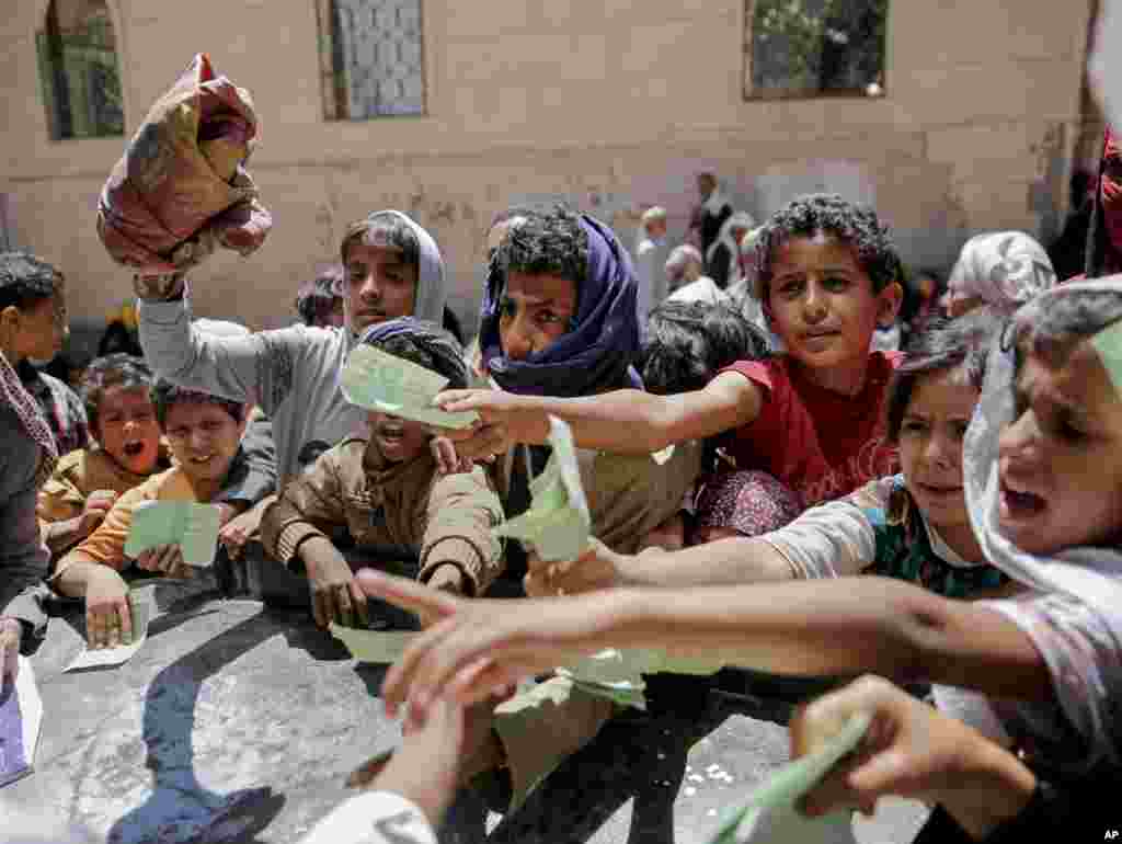 Yemenis present documents in order to receive food rations provided in Sana'a, Yemen.