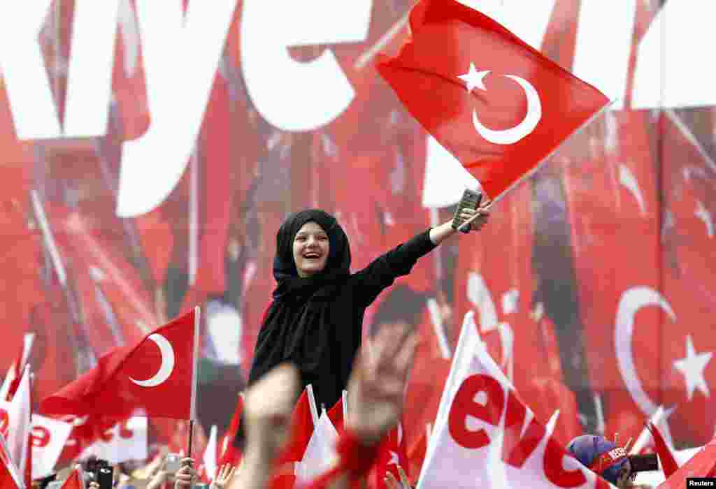 Supporters of Turkish President Tayyip Erdogan wave national flags during a rally for the upcoming referendum in Konya, Turkey.