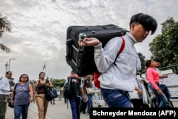 Venezuela -- Venezuelans cross the Simon Bolivar International Bridge into the Colombian border city of Cucuta on January 10, 2019. - Venezuelan President Nicolas Maduro swore in on Thursday for a second term.