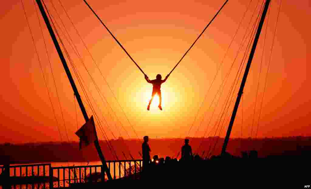 An Indian youth takes part in a 'bunjee jumping' activity at sunset during the 'Bhoj Adventure Festival 2017' in Bhopal, Feb. 25, 2017.