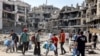 La gente camina entre escombros y edificios dañados en el distrito de Tuffah, al este de la ciudad de Gaza, el 8 de julio de 2024, en medio del conflicto en curso en el territorio palestino entre Israel y Hamás.