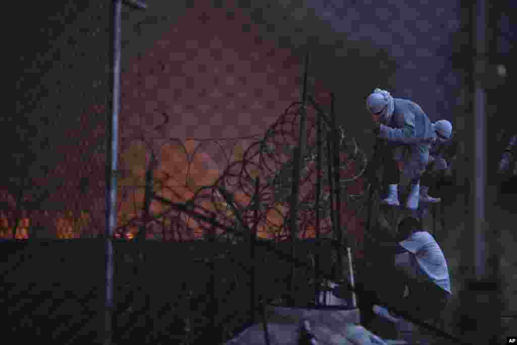 Inmates climb to the roof as a fire breaks out during a riot at the youth and men's reformatory, Centro Correccional Etapa II, in San Jose Pinula, Guatemala, March 19, 2017.
