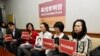 FILE - In this photo taken March 24, 2017, Lee Ching-yu, third from right holds up a photo of her missing husband and Taiwanese pro-democracy activist Lee Ming-che during a press conference with other representatives of non-governmental organizations calling for help to find his whereabouts in Taipei, Taiwan.