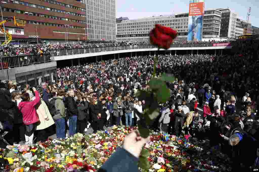 People attend a memorial ceremony at Sergels Torg plaza in Stockholm, near a department store where a truck drove into two days before. Four people died and fifteen were injured.