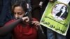 An Egyptian woman cuts her hair during a demonstration in Tahrir Square, Cairo, Egypt, Tuesday, Dec. 25, 2012.