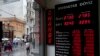 People walk past a currency exchange office in Istanbul, Turkey, June 8, 2015. The Turkish currency dropped to a record low against the dollar over the political uncertainty, trading at 2.8 lira against the dollar. 