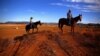 FILE - Farmer Scott Cooper and his daughter Charlie ride their horses along a fence in a drought-affected paddock on their property named "Nundah," south of the central New South Wales town of Gunnedah in Australia, July 21, 2018.