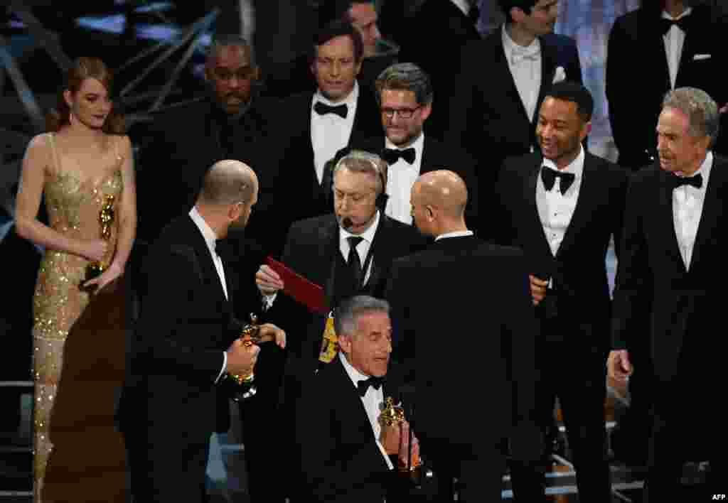"La La Land" producer Jordan Horowitz (2L) speaks to stage manager Gary Natoli (C), reading the winners card, after "La La Land" mistakenly won the best picture instead of "Moonlight" at the 89th Oscars in Hollywood, California, Feb. 26, 2017.