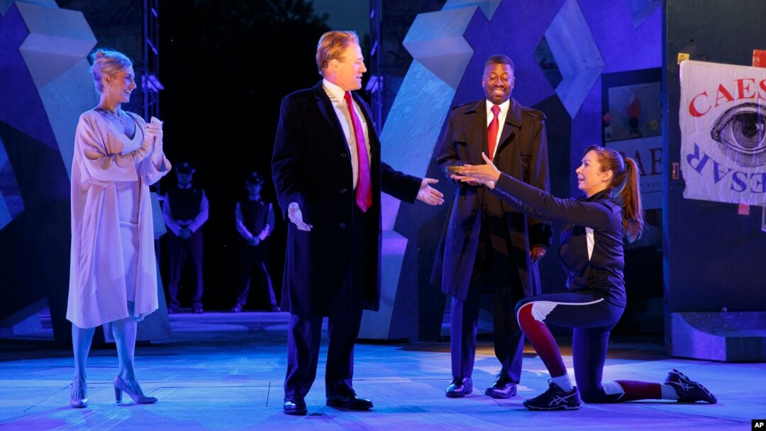 In this photo provided by The Public Theater, Tina Benko, left, portrays Melania Trump in the role of Caesar's wife, Calpurnia, and Gregg Henry, center left, portrays President Donald Trump in the role of Julius Caesar during a dress rehearsal of The Public Theater's Free Shakespeare in the Park production of Julius Caesar, in New York. Rounding out the cast on stage is Teagle F. Bougere as Casca, and Elizabeth Marvel, right, as Marc Anthony. (Joan Marcus/The Public Theater via AP)