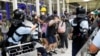 8月13日，防暴警察使用胡椒水驱散反送中大游行的抗议者。在此之前，一名女性抗议者在香港国际机场的集会中眼部受伤。