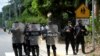 FILE - Nicaraguan police officers block journalists working outside the house of opposition leader Cristiana Chamorro after prosecutors sought her arrest, in Managua, Nicaragua, June 2, 2021.