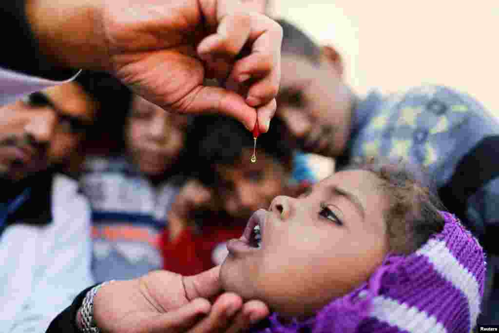 A girl is given vitamin A drops during a house-to-house vaccination campaign in Sanaa, Yemen February 20, 2017.