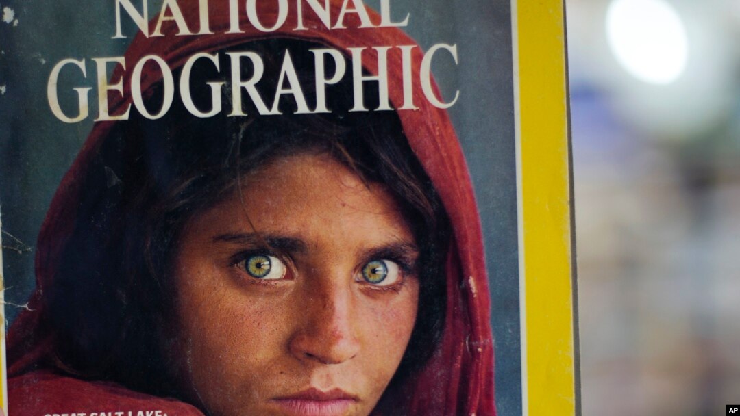 Pakistan's Inam Khan, owner of a book shop shows a copy of a magazine with the photograph of Afghan refugee woman Sharbat Gulla, from his rare collection in Islamabad, Pakistan, Oct. 26, 2016. 