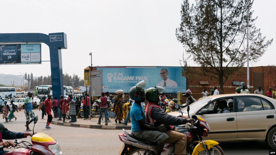 FILE - A passenger rides on a fuel-powered moto-taxi in Kigali, Rwanda, July 30, 2017. Rwanda is introducing electric motorcycles, with more than 600 being built for use in the country.