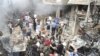A crowd gathers in front of a building and car damaged after a bomb explosion in the Mezzeh 86 area in Damascus, in this handout photograph released by Syria's national news agency SANA, November 5, 2012. 