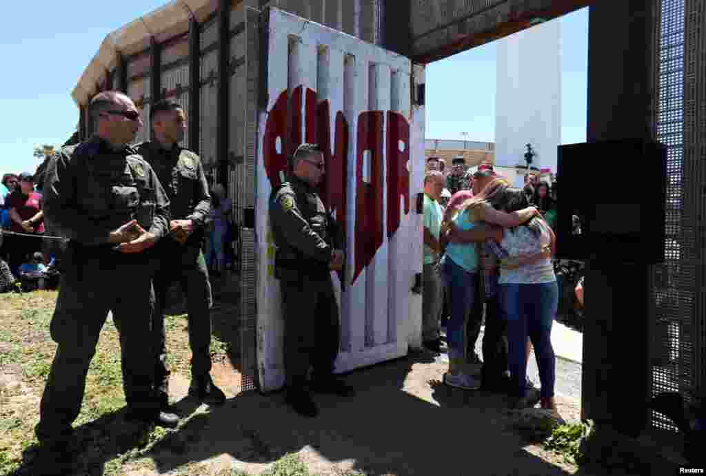 Member of the Reyes family hug as they are reunited for three minutes as U.S. Border patrol agents open a single gate along the Mexico border as part of Children's Day in Mexico, at Border Field State Park in San Diego, California, April 30, 2017.