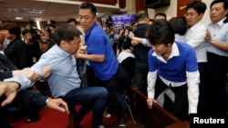 Ruling Democratic Progressive Party (DPP) legislator Chao Tien-lin, left, scuffles with opposition Kuomintang (KMT) legislators during budget meeting for the infrastructure development program, at the Legislative Yuan in Taipei, Taiwan, July 18, 2017.