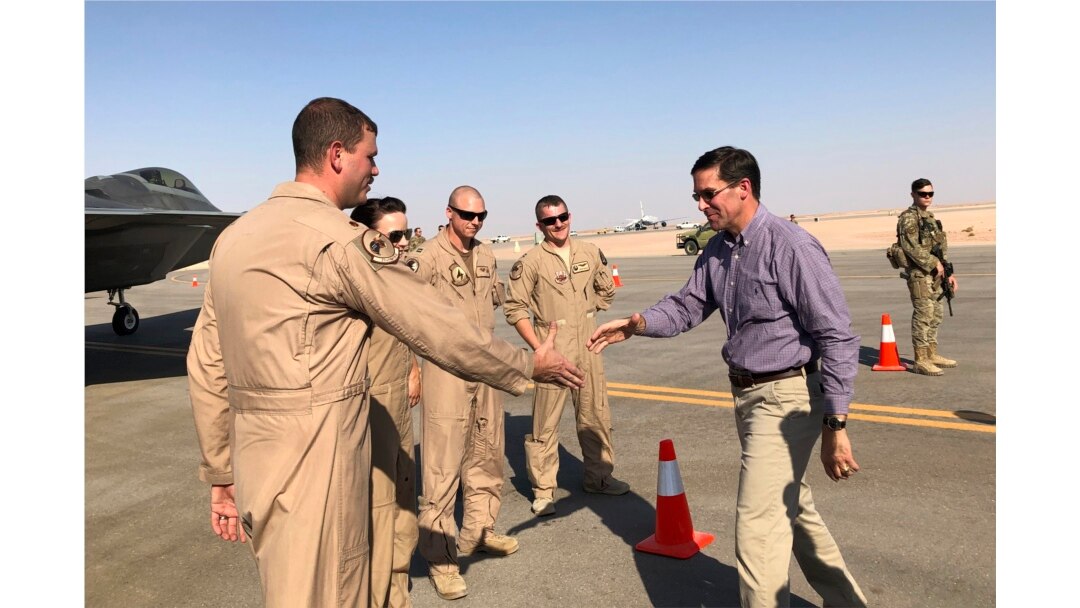Defense Secretary Mark Esper talks with U.S. troops in front of an F-22 fighter jet deployed to Prince Sultan Air Base in Saudi Arabia, Tuesday, Oct. 22, 2019. (AP Photo/Lolita Baldor)