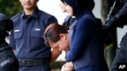 Indonesian suspect Siti Aisyah, center, arrested in the death of Kim Jong Nam, is escorted by police officers as she leaves at a court house in Sepang, Malaysia, April 13, 2017.