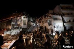 Civilians and civil defense members look for survivors at a site damaged after suspected Russian airstrikes on the Syrian rebel-held city of Idlib, Syria, late May 30, 2016. The strikes killed at least 50 people and left dozens more injured.