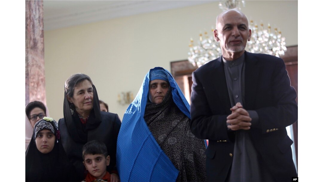 Afghan President Ashraf Ghani, right, meets with National Geographic's famed green-eyed "Afghan Girl" Sharbat Gulla at the Presidential palace in Kabul, Afghanistan, Nov. 9, 2016.
