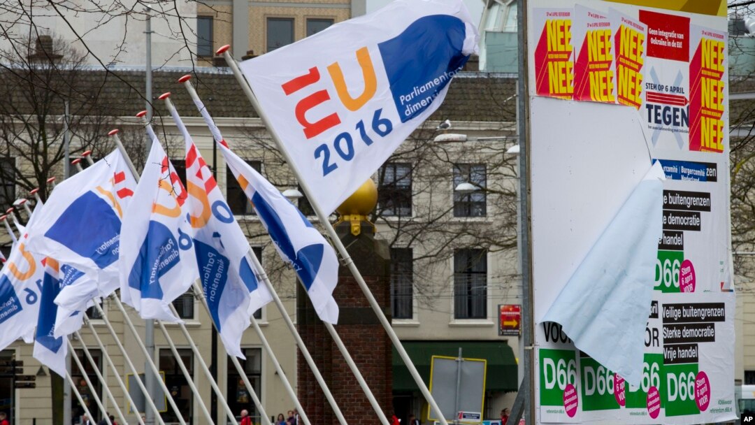 FILE - Flags of the Dutch EU presidency and posters for a non-binding referendum on the EU-Ukraine association agreement are seen in The Hague, Netherlands, April 6, 2016. The resulting "no" vote was greeted with concern in the West, but with delight in Moscow.