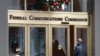 FILE - A person with a smart phone enters the Federal Communications Commission office in Washington on Dec. 14, 2017. The FCC said on Nov. 8, 2024, that its enforcement bureau is investigating racist text messages sent anonymously to Black Americans across the country.