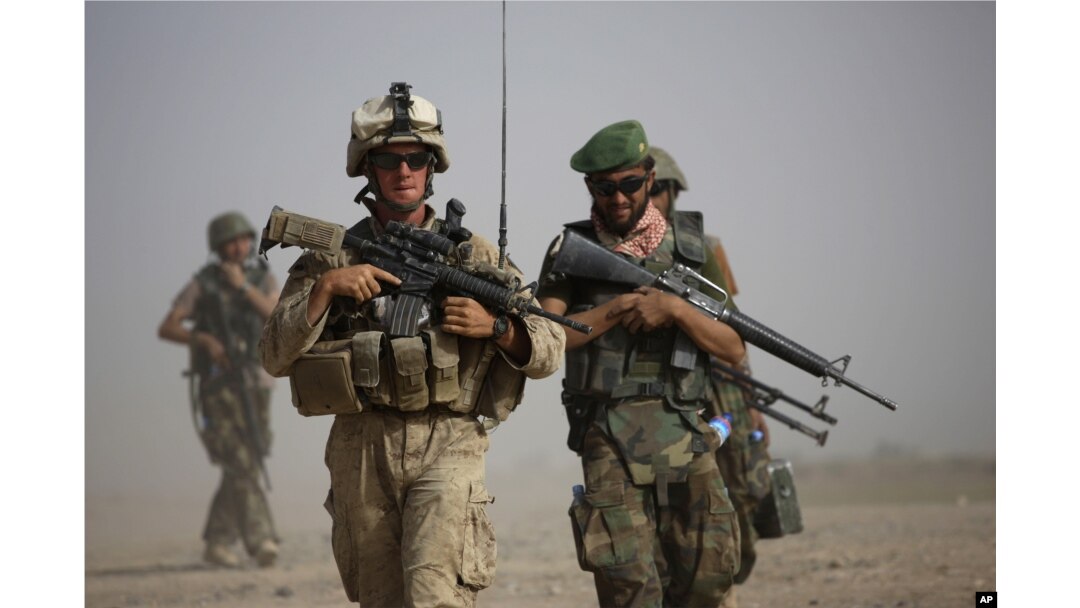 FILE - A U.S. Marine and an Afghan soldier are seen on joint patrol in Helmand province, southern Afghanistan, Oct. 3, 2009.