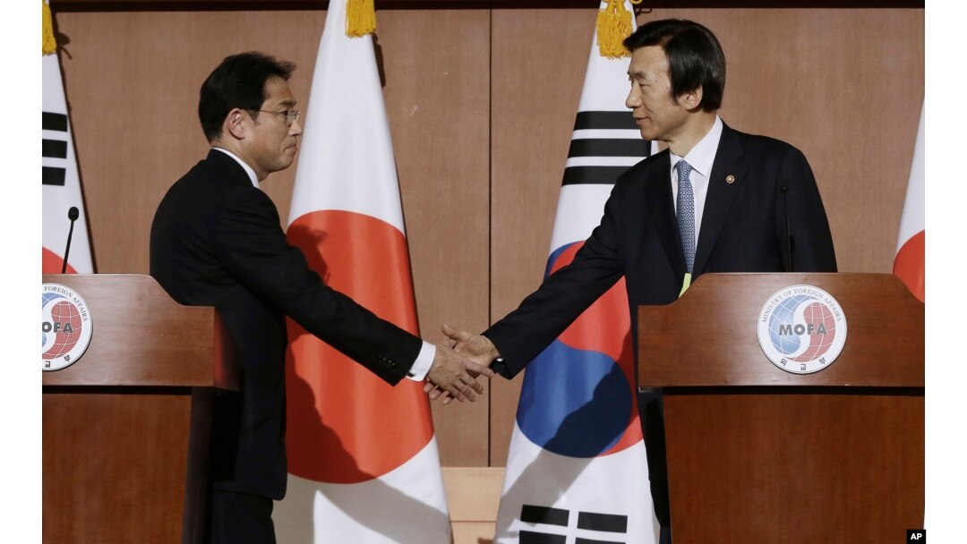 South Korean Foreign Minister Yun Byung-se, right, shakes hands with Japanese counterpart Fumio Kishida after a joint press conference in Seoul, South Korea, Dec. 28, 2015.