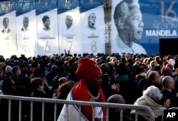 Members of the public sit beneath a banner of former President Nelson Mandela, where former U.S. President Barack Obama delivered his speech at the 16th Annual Nelson Mandela Lecture at the Wanderers Stadium in Johannesburg, South Africa, July 17, 2018.