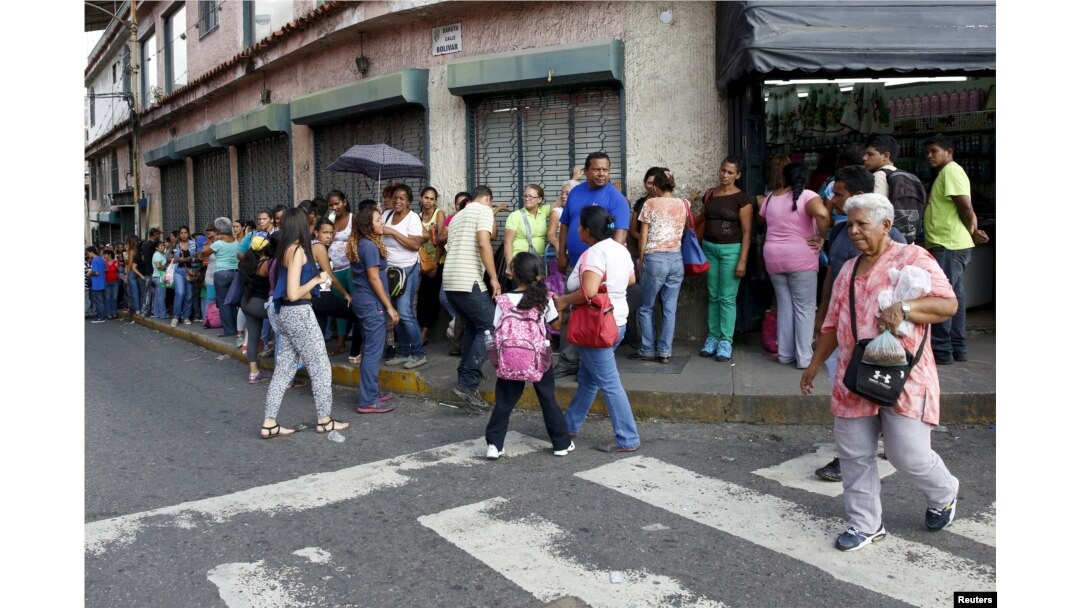 FILE - People wait in a line to buy staple goods outside a supermarket in Caracas, Venezuela, Oct. 20, 2015.