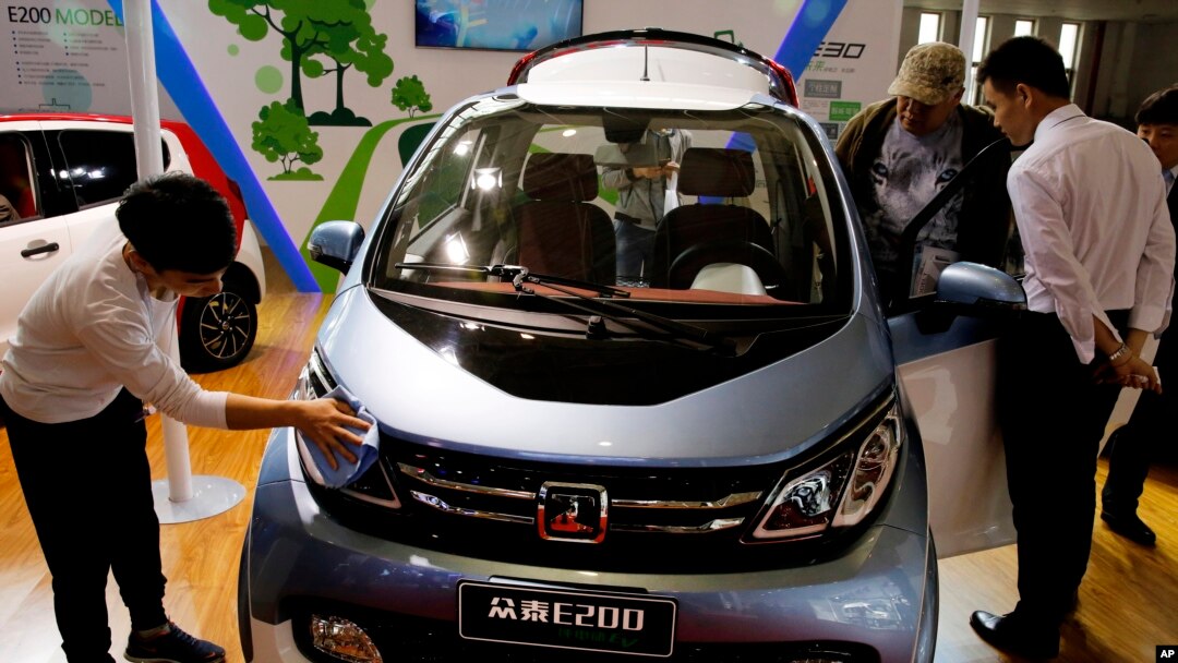 FILE - Visitors at the Beijing International Automotive Exhibition look at an electric vehicle by Chinese automaker Zotye on display in Beijing, China, April 26, 2016.