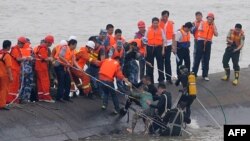 一名幸存者（绿色上衣）被潜水员从“东方之星”客轮残骸中救出。(2015年6月2日)